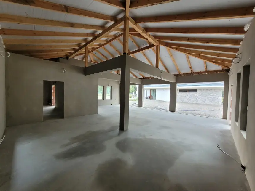 Zrealizowany projekt - wytynkowane pomieszczenie z oknami i filarami z perspektywy wewnątrz budynku